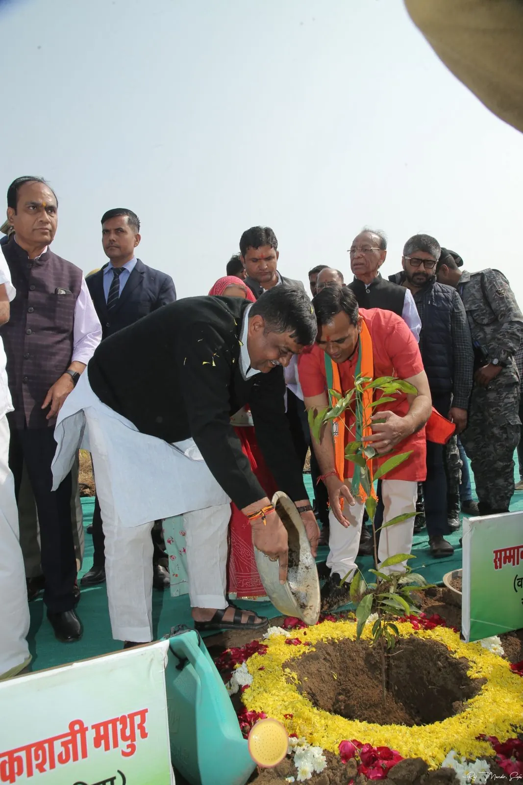 Dignitaries water a newly planted sapling ringed with marigold petals at Pali Oxygen Park